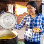 mujer joven guaraní mostrando sopa de maní tradicional del chaco en olla